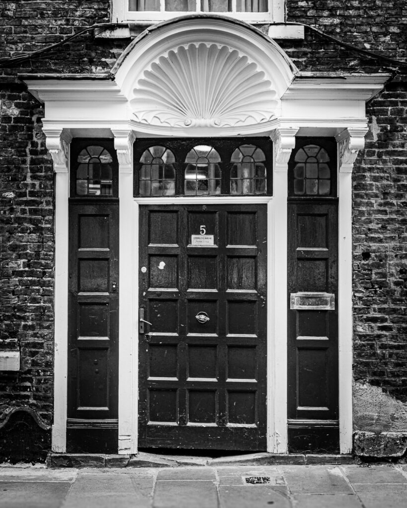 Ornate Georgian doorway with shell canopy and sidelights in Durham's historic Bailey quarter by Michael Dutson architecure photography